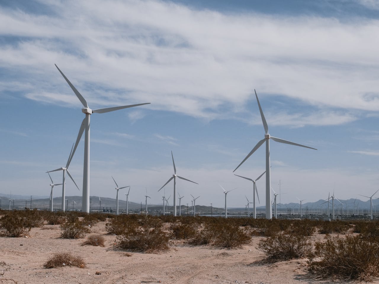 A scenic view of wind turbines in a desert, symbolizing clean, renewable energy technology.